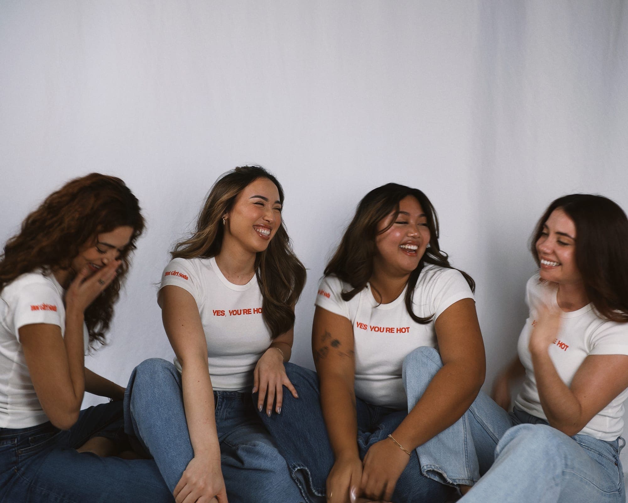 Friends laughing together wearing Hot Girl Soda merchandise